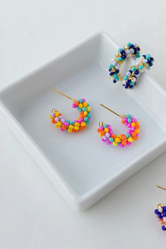 Handmade colorful beaded hoop earrings displayed on a white tray, Jabatzelet jewelry