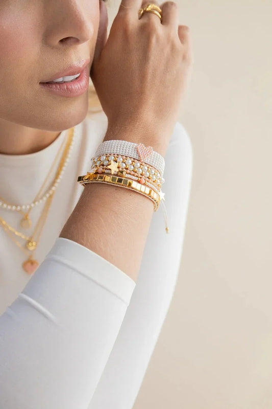 Woman wearing handmade gold and pearl jewelry bracelets and necklaces from Jabatzelet
