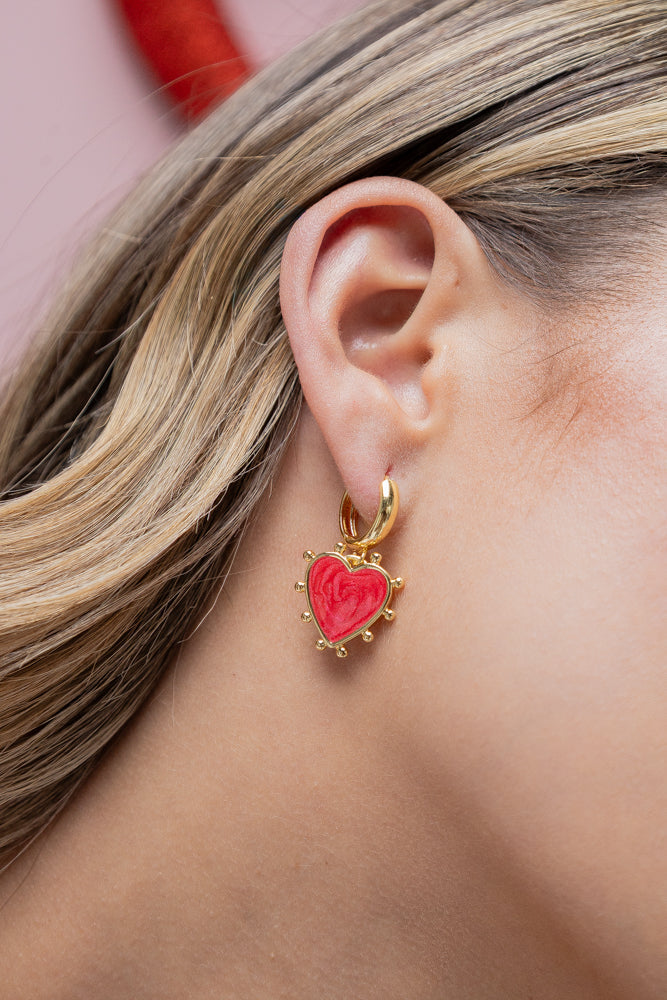 Woman wearing handmade gold heart earrings, bracelet, and chain necklace by Jabatzelet jewelry